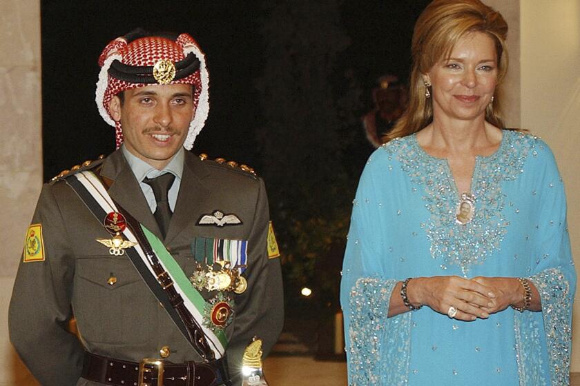 FILE - Jordan's Crown Prince Hamzeh, left, with his mother Queen Noor, right, during his wedding ceremony in Amman, Jordan, on May 27, 2004. The former queen of Jordan says her son, Prince Hamzah, is still not free after having been put under house arrest by his half-brother, King Abdullah II, seven months ago. Queen Noor made the assertion in a tweet late on Wednesday, Nov. 3, 2021, while marking the birthday of one of her granddaughters. (AP Photo/Hussein Malla, File)