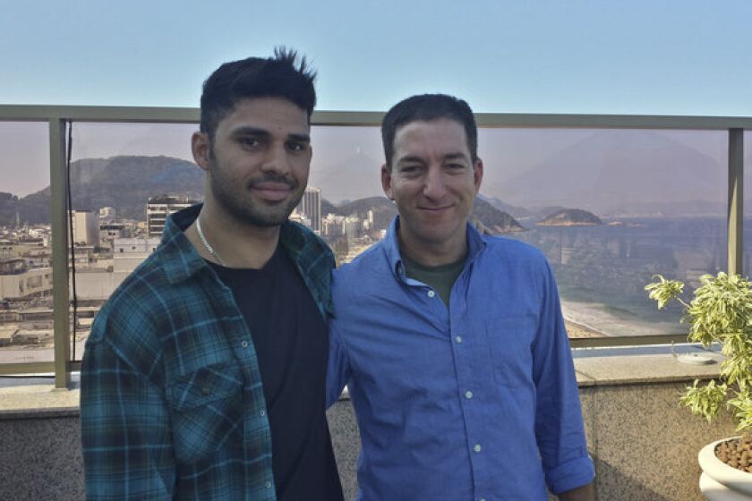 Guardian journalist Glenn Greenwald, right, and his partner David Miranda, are shown together in an undated photo at an unknown location. Miranda was detained for nine hours Sunday at Heathrow Airport.