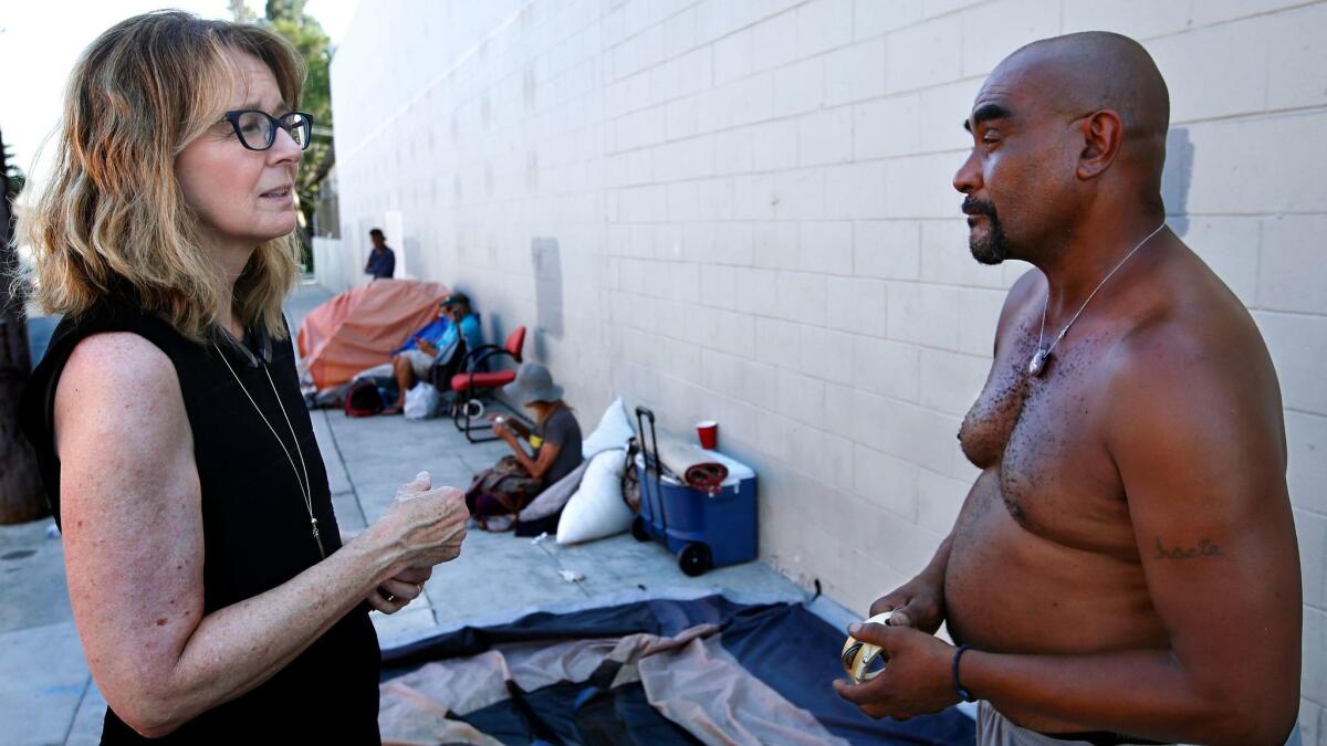 Kerry Morrison talks to Keith Weston, 52, at a homeless encampment on El Centro Avenue in Hollywood.