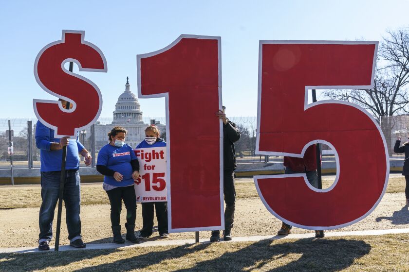 FILE - Activists appeal for a $15 minimum wage near the Capitol in Washington, Thursday, Feb. 25, 2021. According to the Economic Policy Institute, the federal minimum wage in 2021 was worth 34% less than in 1968, when its purchasing power peaked. (AP Photo/J. Scott Applewhite, File)