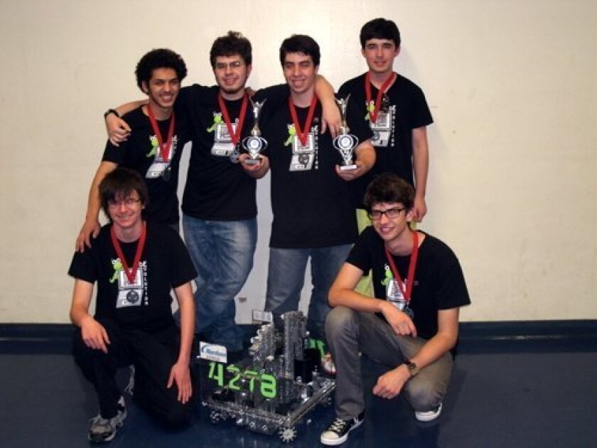 Posing with their winning robot and two trophies are De-Evolution members Noah Sutton-Smolin and Nic Stone (kneeling), and standing are: Yousuf Soliman, Colin Murphy, Tristan Murphy, Ryan Lee. Not pictured: Merry Hodgman.