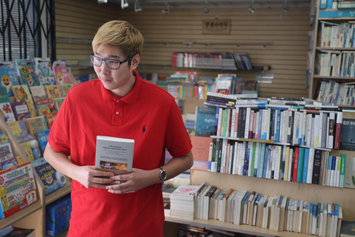 Joe Choi prepares to purchase a book at Aladdin Fullerton, a Korean bookstore in La Mirada.