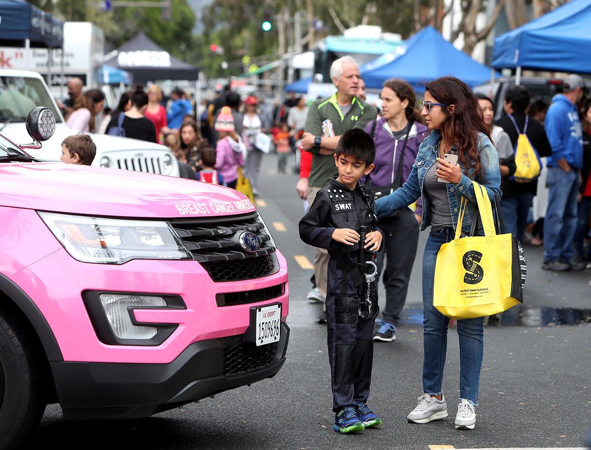 Wearing a SWAT costume, Arian Norouzi, 9 of Glendale, and his mother Khatereh Gharagozloo look over the Breast Cancer Awareness police SUV at the annual Glendale Police Dept. Open House, at headquarters in Glendale on Saturday, Oct. 13, 2018. The event included live police K9 demonstrations, performances by the Glendale High School Dance Team and a variety of activities.