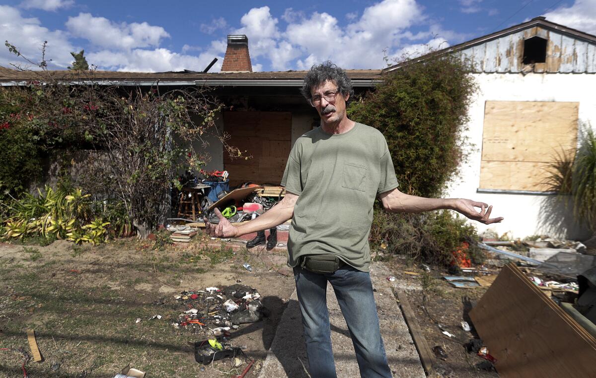 George Contreras stands in front of his burnt-out house on Lake Street in Burbank. He said he finds himself wondering, "What else am I supposed to do?" The 60-year-old lost an 8-year-old dog named Blackie in a fire on Feb. 13 as well the mementos of family members who have passed away.