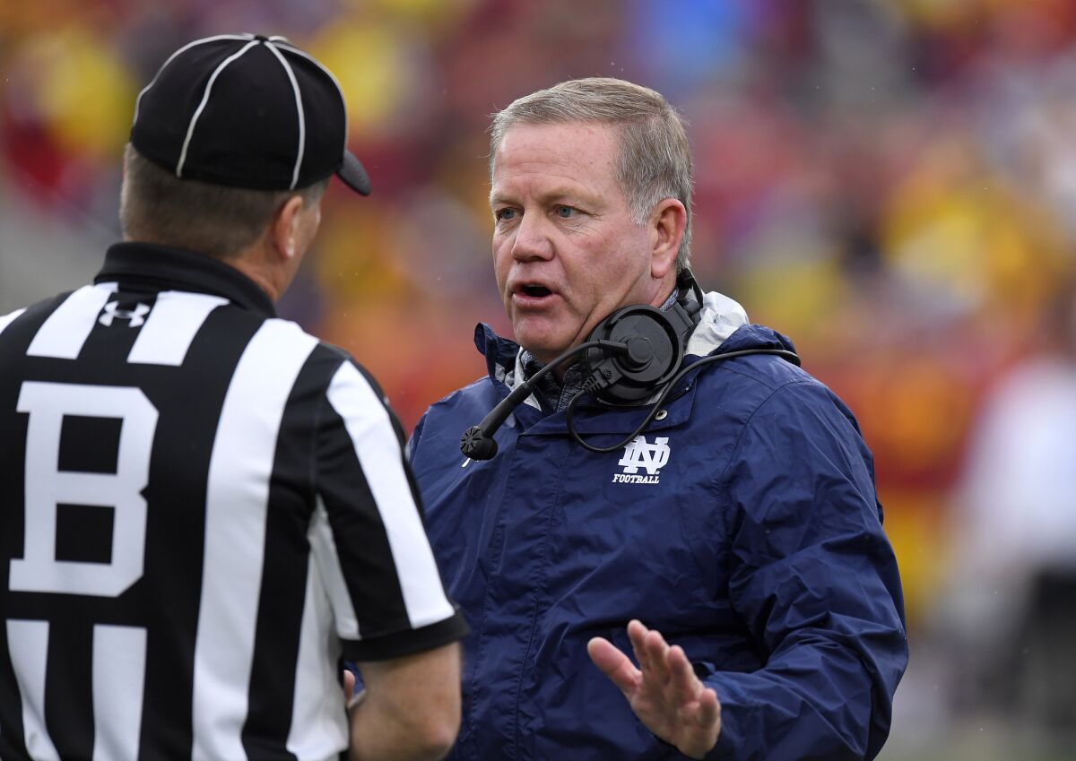 Notre Dame Coach Brian Kelly, right, talks to an official during the first half of a game against USC on Nov. 26.