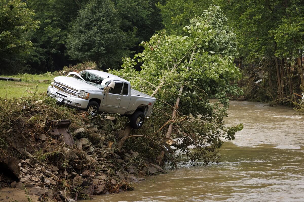Una camioneta se encuentra varada en la orilla de un río, 