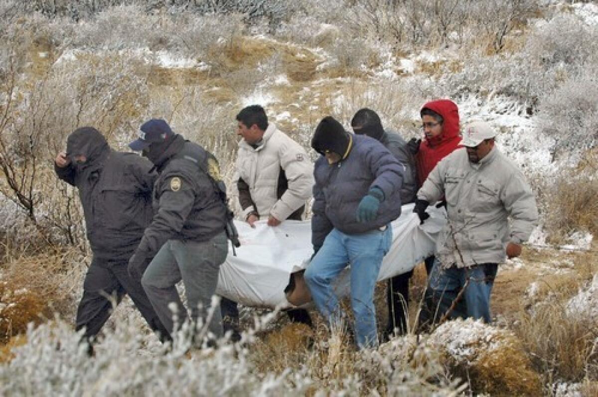 Mexican federal police officers carry a body in Villa Ahumada, a town in the state of Chihuahua 80 miles south of Ciudad Juarez, after a series of events that included deadly shootouts between the army and gunmen who had abducted nine people and killed six of them.