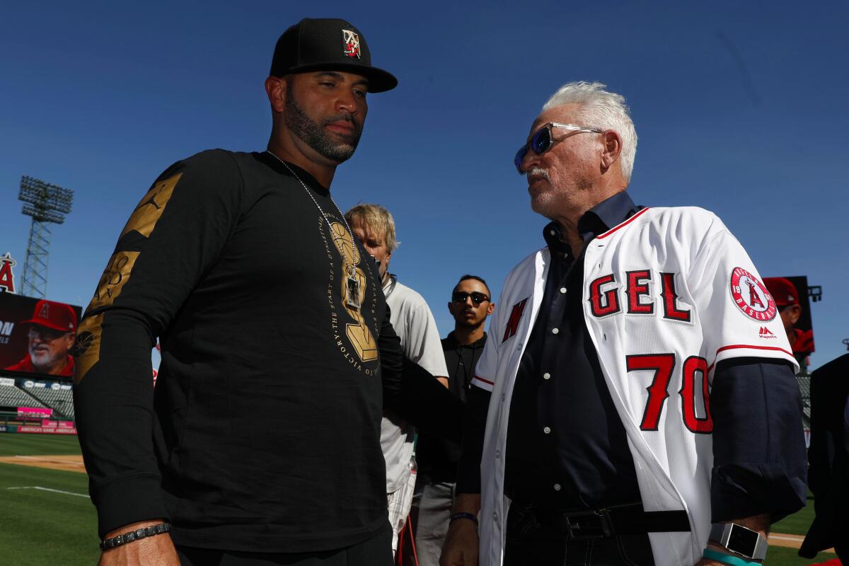 Albert Pujols and Joe Maddon speak on the field in 2019