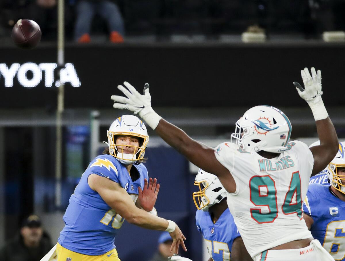 Chargers quarterback Justin Herbert throws a pass while pressured by Dolphins defensive tackle Christian Wilkins.