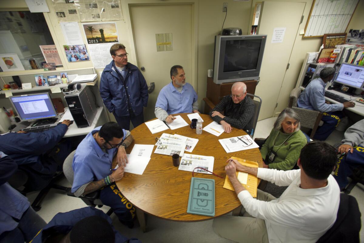 A group of inmates at San Quentin State Prison meet with three civilian advisors in the prison newsroom. The newspaper is being honored by the Society of Professional Journalists.