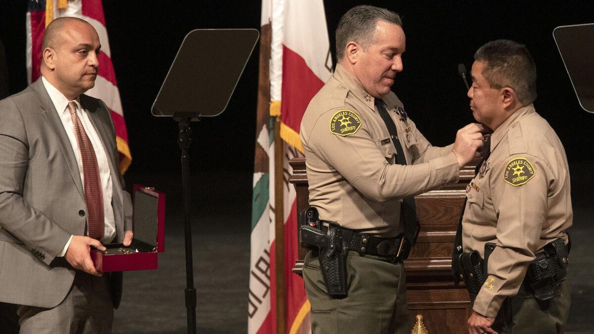 Caren Carl Mandoyan looks on as Alex Villanueva, the new Los Angeles County Sheriff, pins officers during a ceremony in Monterey Park, Calif. on December 3, 2018.