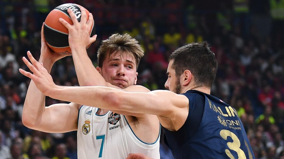 Real Madrid's Luka Doncic tries to power his way past Fenerbahce's Nikola Kalinic during the Euroleague championship game on May 20.