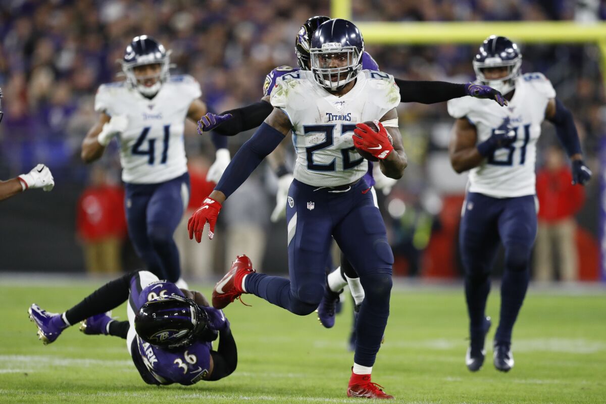 Tennessee Titans running back Derrick Henry (22) runs past Baltimore Ravens strong safety Chuck Clark (36) during the second half of NFL divisional playoff game Saturday in Baltimore.