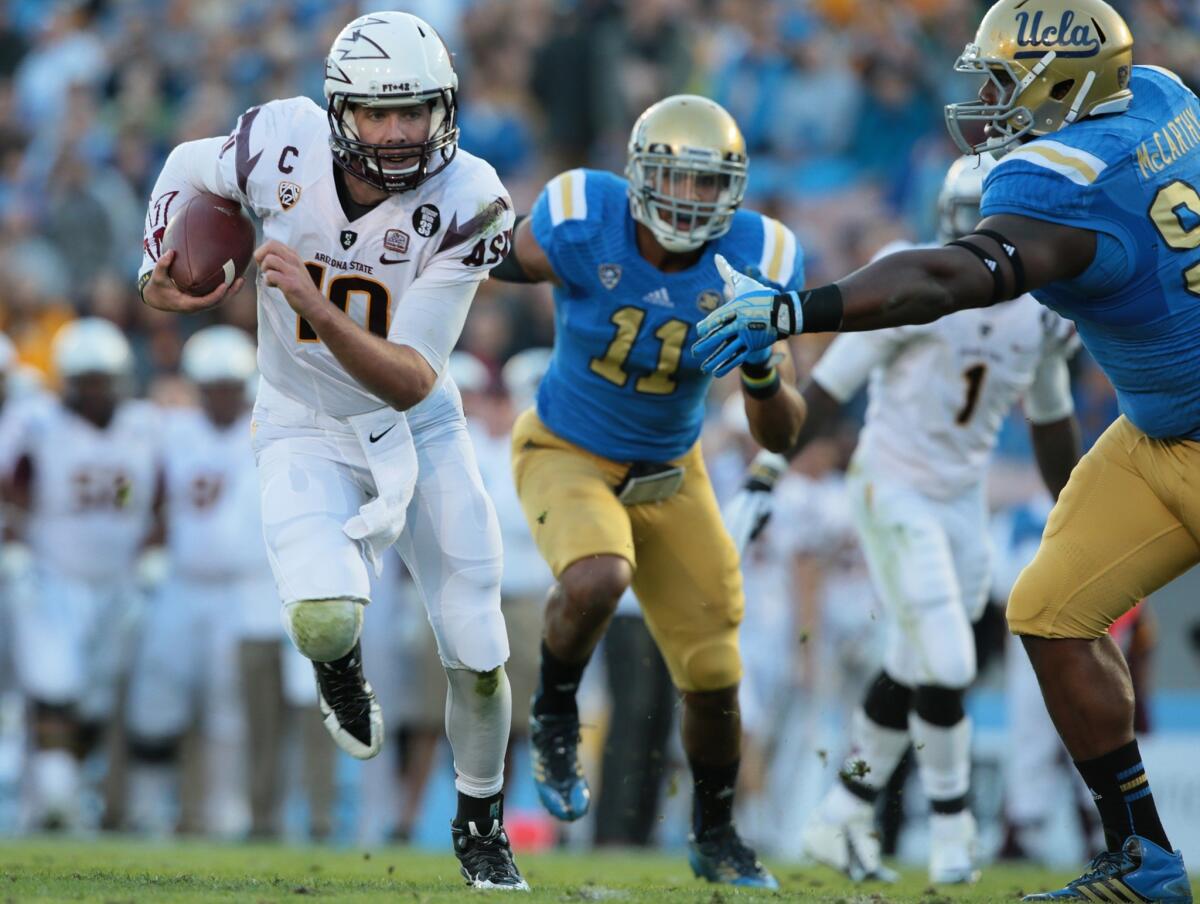 UCLA defensive tackle Ellis McCarthy can't get a hand on Arizona State quarterback Taylor Kelly as he runs for a touchdown in the first quarter.