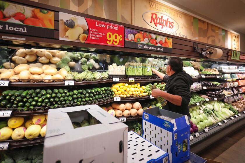 Victor Marcus, a produce clerk at the Ralphs supermarket in the La Jolla Square shopping center, restocks produce at the store, early in the morning, March 19, 2020 in San Diego, California.