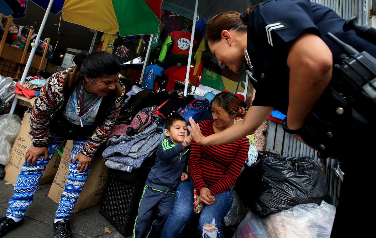 LAPD Officer Norma Perez talks with vendors as she walks a "foot beat" along Cesar Chavez Avenue in Boyle Heights.