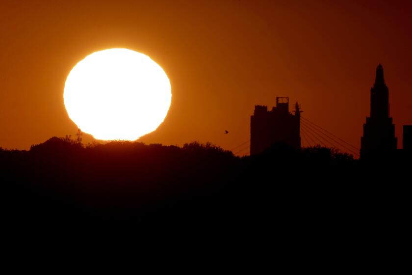 FILE - The sun sets beyond the downtown skyline of Kansas City, Mo., as the autumnal equinox marks the first day of fall Sunday, Sept. 22, 2013. During the equinox, the Earth’s axis and its orbit line up so that both hemispheres get an equal amount of sunlight. (AP Photo/Charlie Riedel, File)