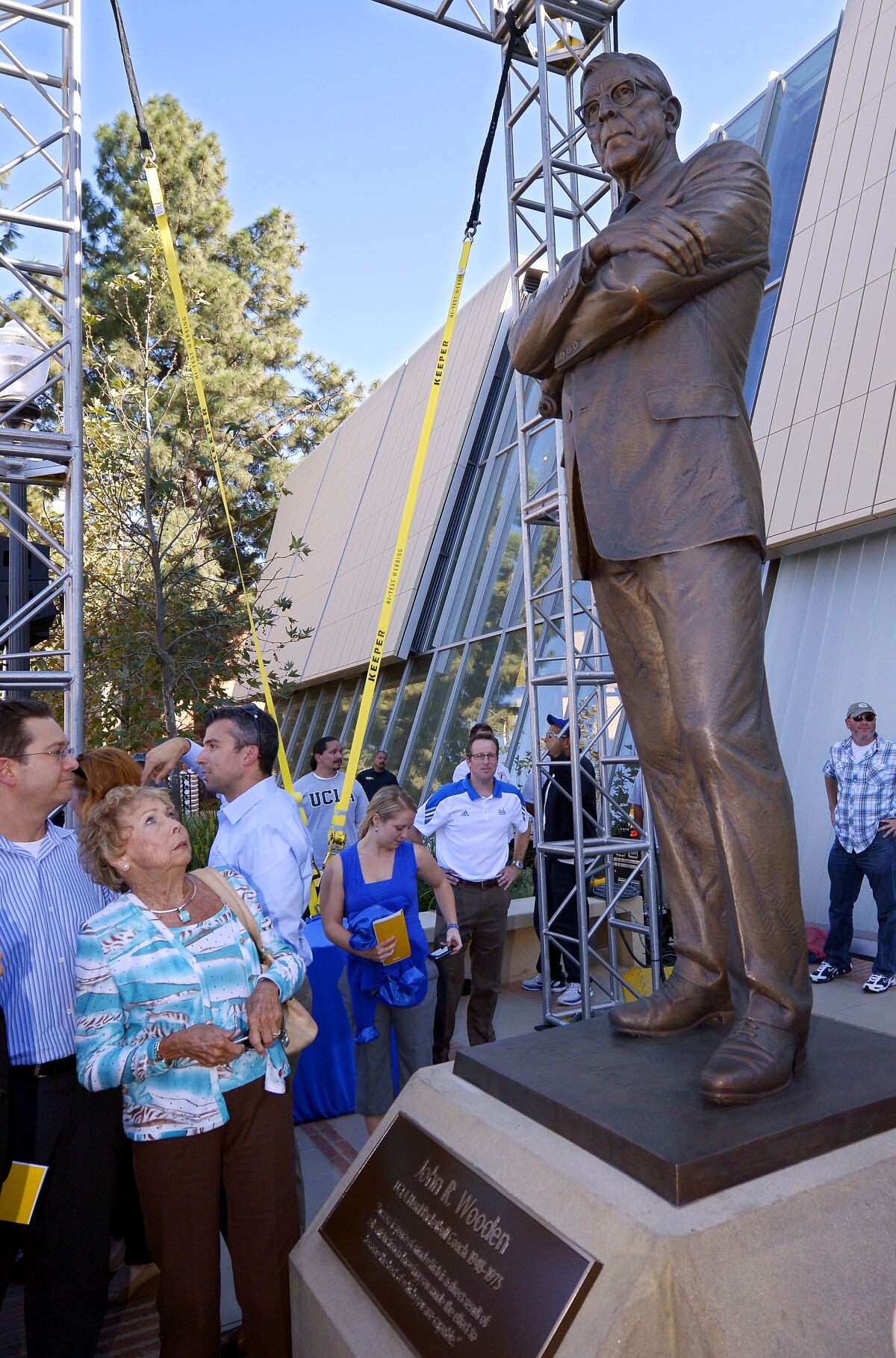 FILE - In this Oct. 26, 2012, file photo, Nan Wooden looks at a statue of her late father, UCLA men's basketball coach John Wooden, after its unveiling outside the new Pauley Pavilion at UCLA in Los Angeles. Nan Wooden died Tuesday, Sept. 14, 2021. She was 87. The school said she died of natural causes at a care facility in the San Fernando Valley, according to family members. She had suffered a series of strokes in recent years. (AP Photo/Mark J. Terrill, File)