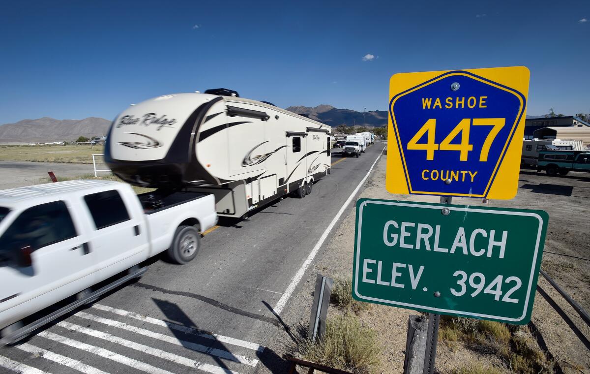 Trucks with trailers travel along Nevada State Route 447 through Gerlach to the Burning Man festival.