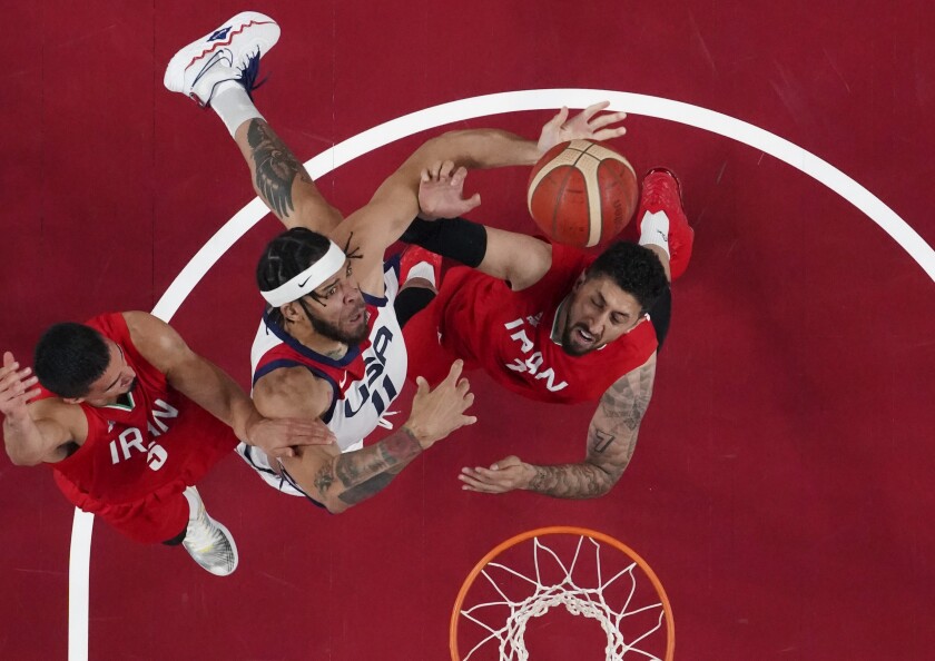 U.S. forward Javale McGee is fouled as he drives to the basket against Iran's Mohammad Hassanzadeh and Pujan Jalalpoor.