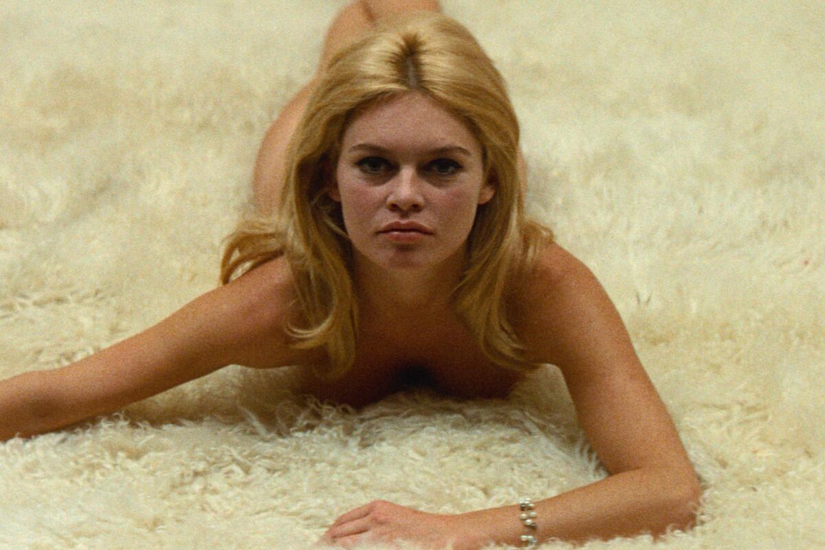 Brigitte Bardot lies prone on a white rug