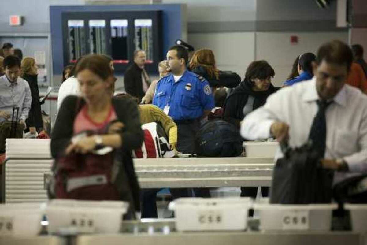 Travelers go through a TSA screening checkpoint at John F. Kennedy International Airport in New York.