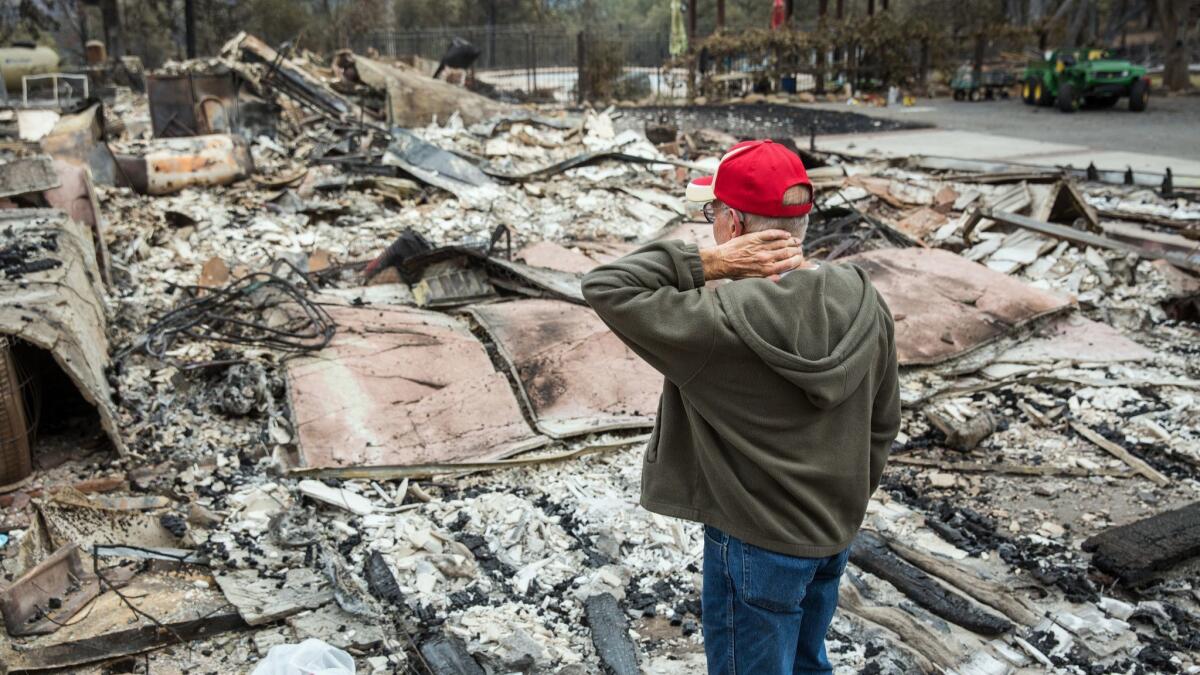 Jay Albertson takes a moment as he views his burned down home of 30 years after it was destroyed by the Valley Fire in 2015. Areas of wine country that were devastated by wildfire now have some of the lowest poverty rates in the U.S., new census data show.