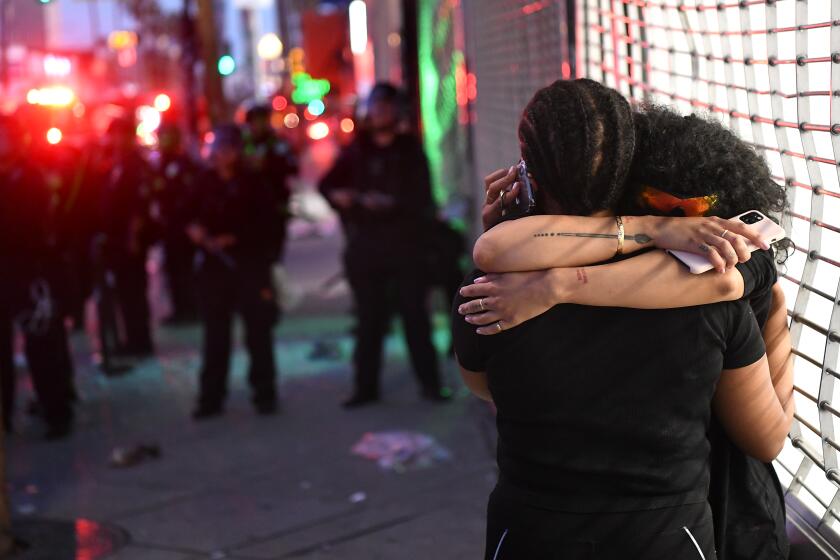 LOS ANGELES, CALIFORNIA MAY 30, 2020-Two women hug each other knowing they will be arrested along with protestors on Fairfax Ave. in Los Angeles Saturday. (Wally Skalij/Los Angeles Times)