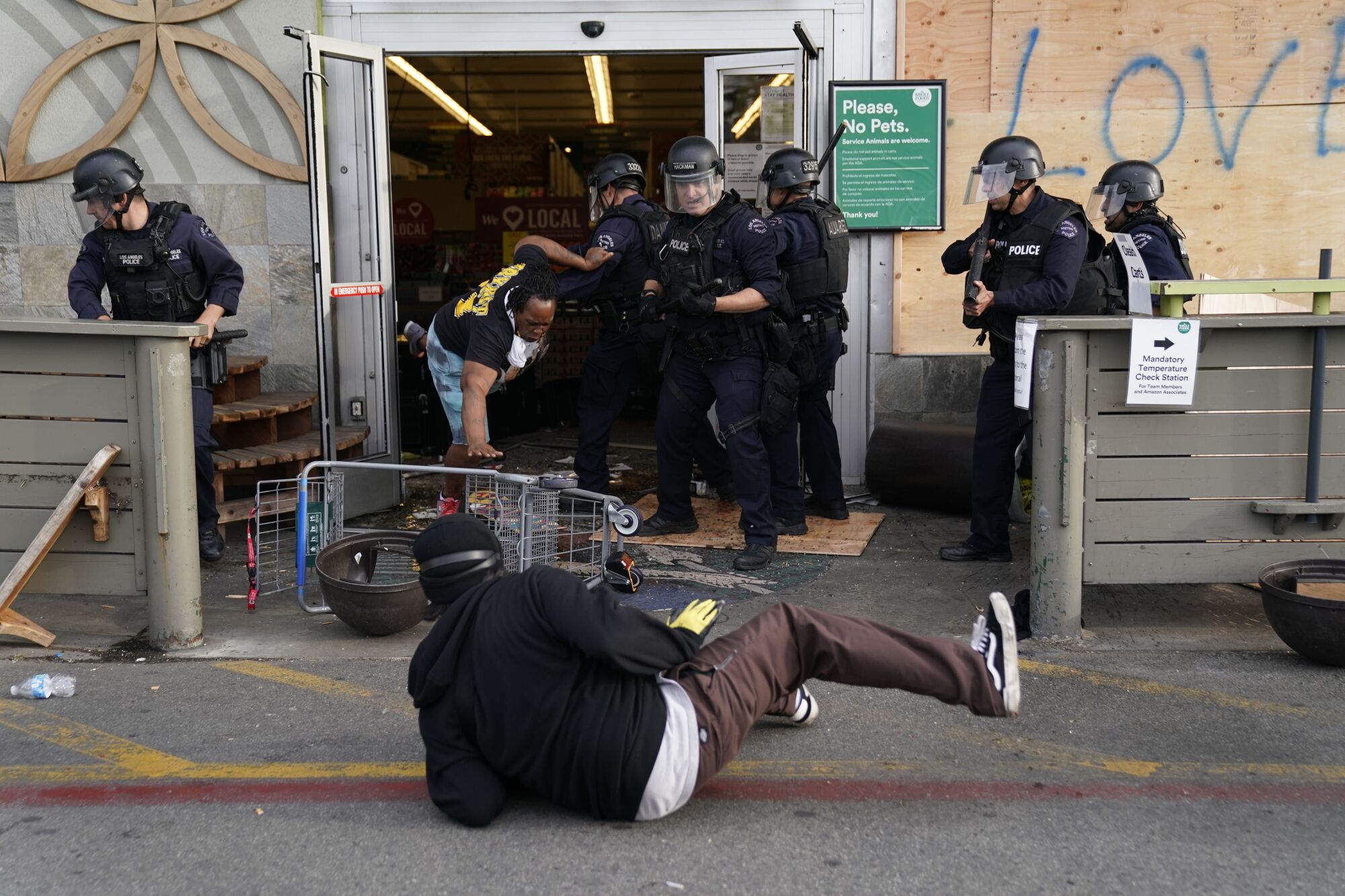 Protesters are thrown out of a Whole Foods Market in L.A.'s Fairfax District on Saturday. 
