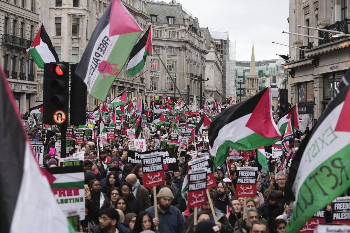 Pro-Palestinian protesters hold up banners, flags and placards during a demonstration in London.