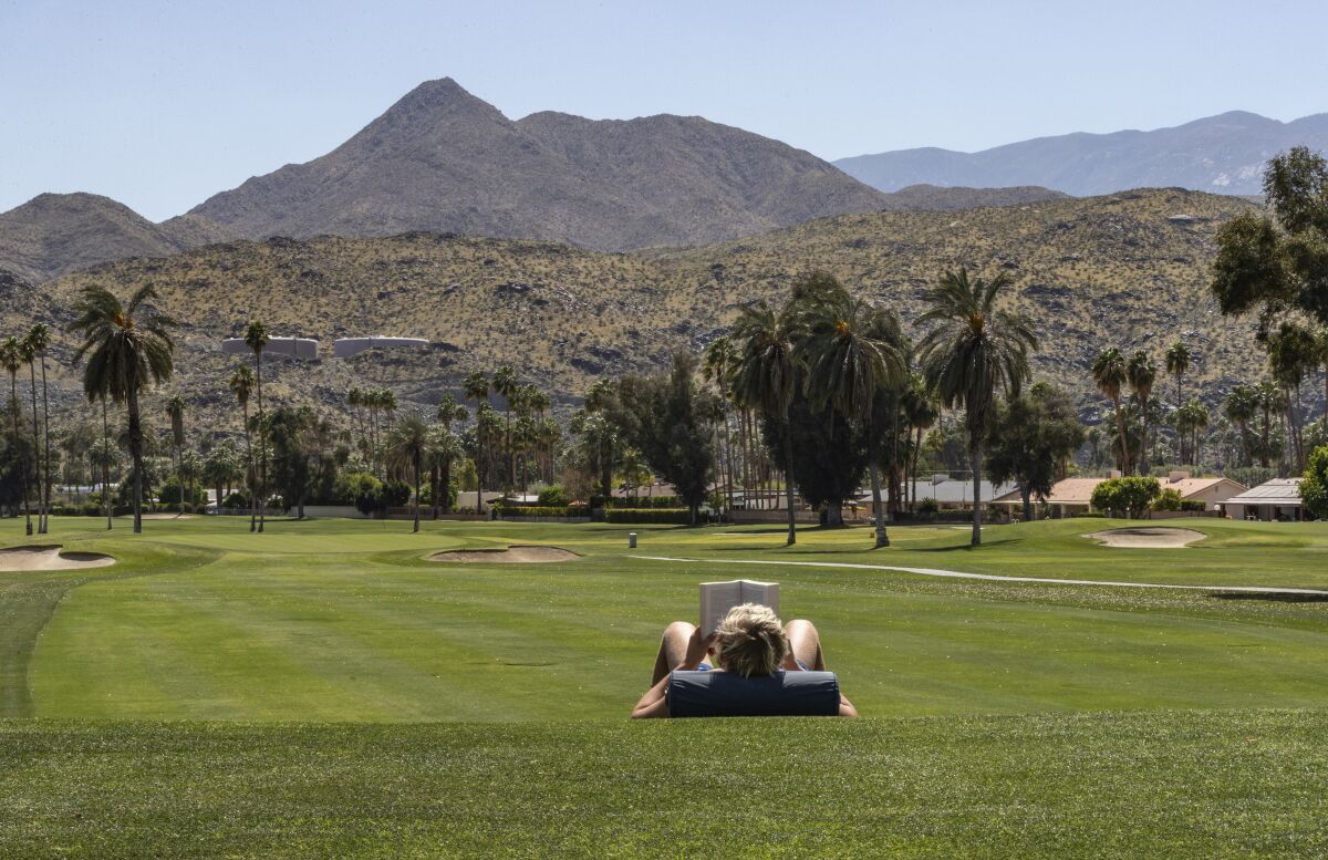 A person lying in the grass on a golf course