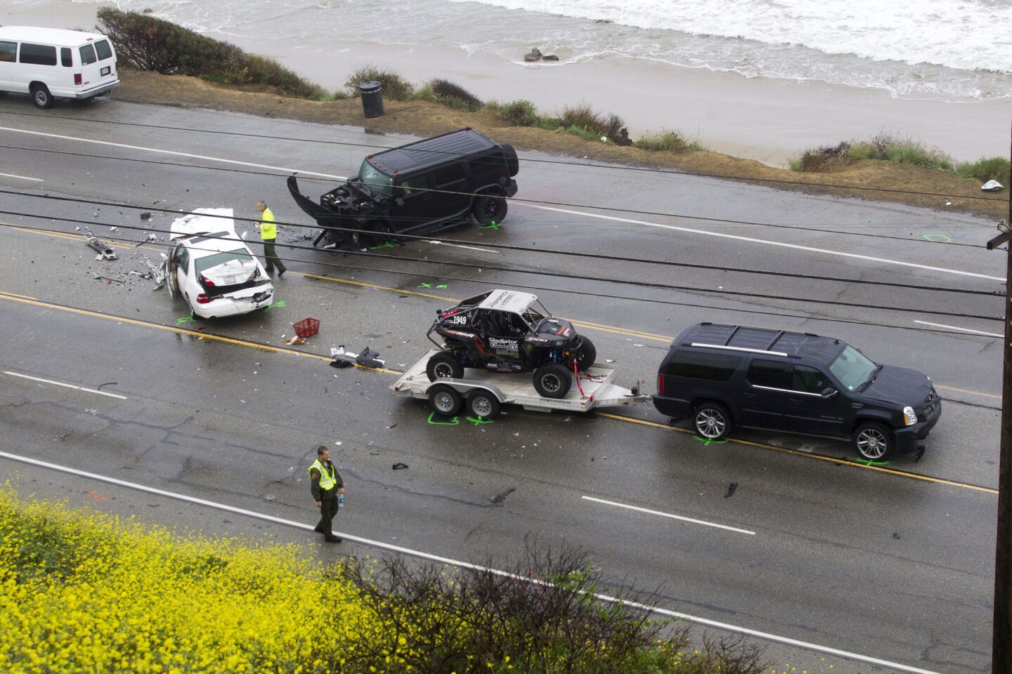 A Los Angeles County Sheriff's deputy photograph the scene of a fatal car crash on Corral Canyon Road in Malibu.