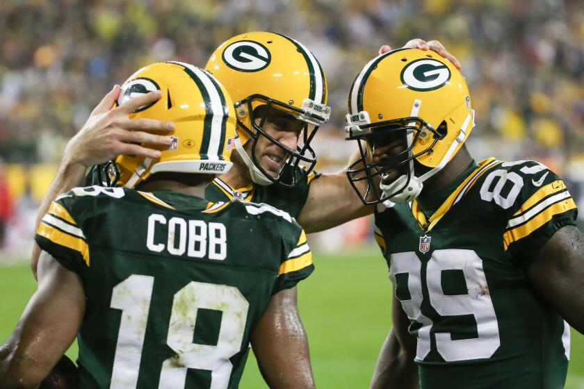 Packers quarterback Aaron Rodgers celebrates with receivers Randall Cobb and James Jones (89) in the third quarter. Rodgers threw five touchdowns, three to Cobb.