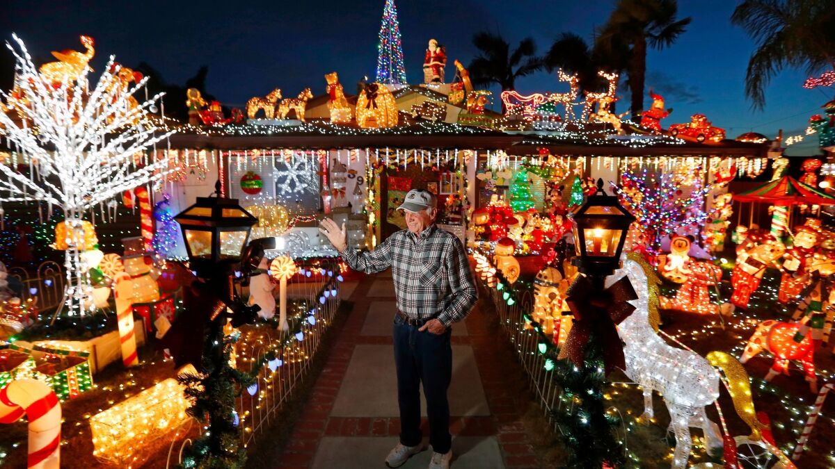 San Marcos resident Bill Gilfillen, 79, waves at passers-by from his elaborate "Christmas on Knob Hill" display, which has more than 100,000 lights.