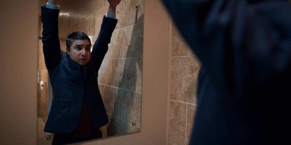 A man mimics the confident pose of a bear in the mirror