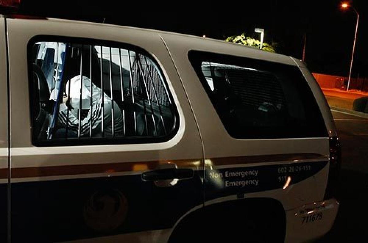 Juan Francisco Perez-Torres sits in the back of a Phoenix police vehicle after he is rescued from kidnappers who demanded $150,000 and 50 pounds of marijuana. Video Q&A >>>