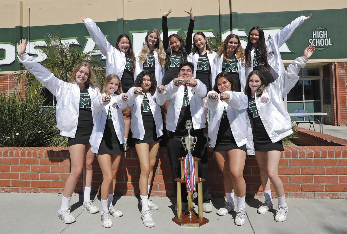Members of the Costa Mesa High School cheerleading team pose with their first-place trophy and CIF rings.