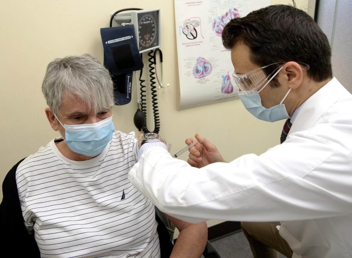 Nicole Picard, izquierda, recibe una dosis de la vacuna de Moderna contra el COVID-19 