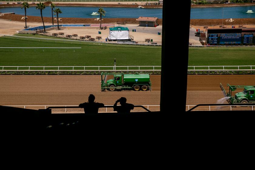 Workers groom the tracks as fans arrive at the Del Mar Racetrack on the day that two horses died in a training accident on July 18, 2019 in Del Mar, California.