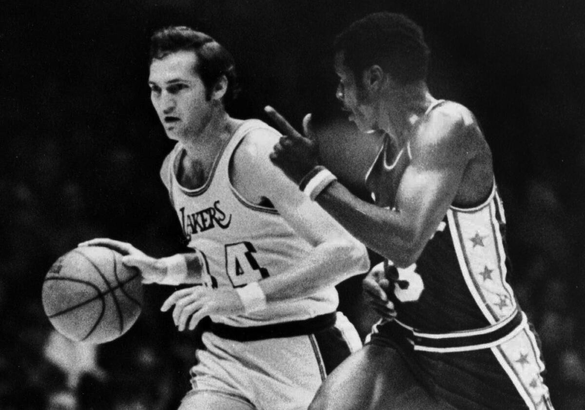 Jerry West, left, handles the ball as he and Fred Carter race down the court on Dec. 19, 1971.