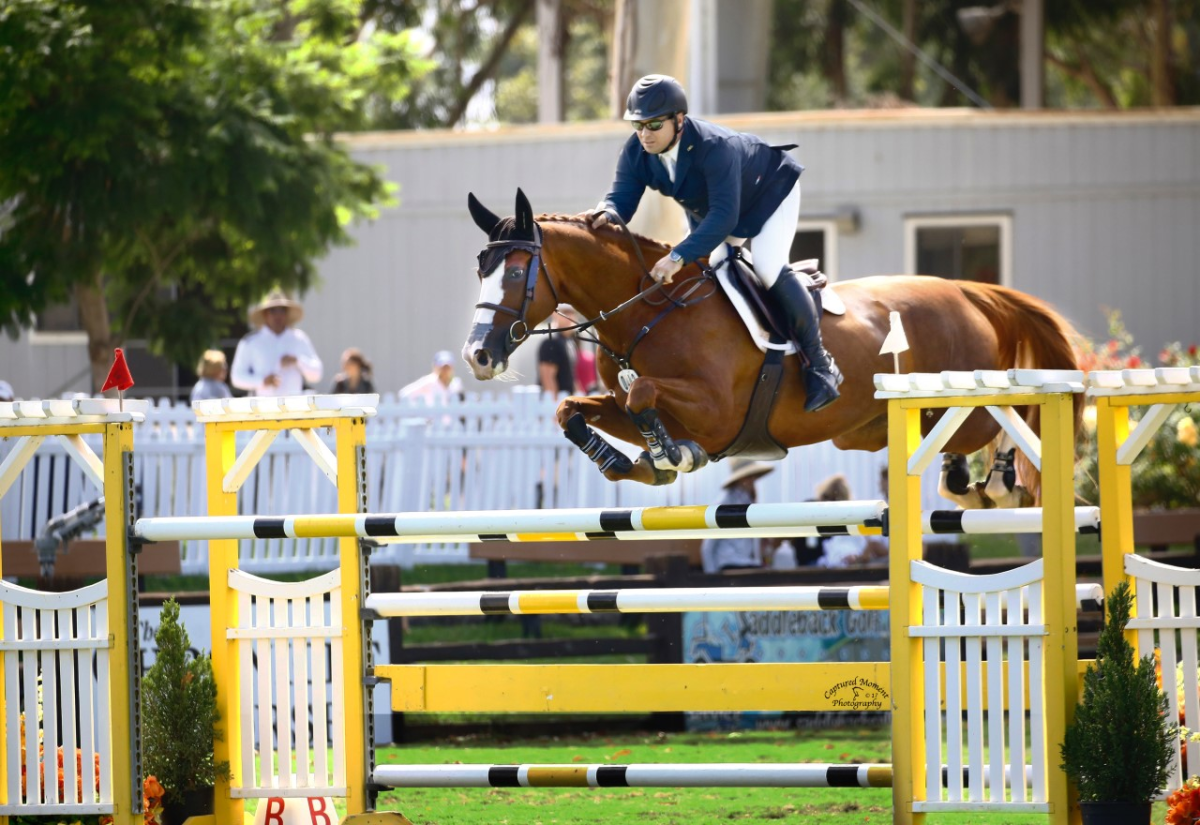 Jason McArdle executes a jump on Elicole during a show horse competition.