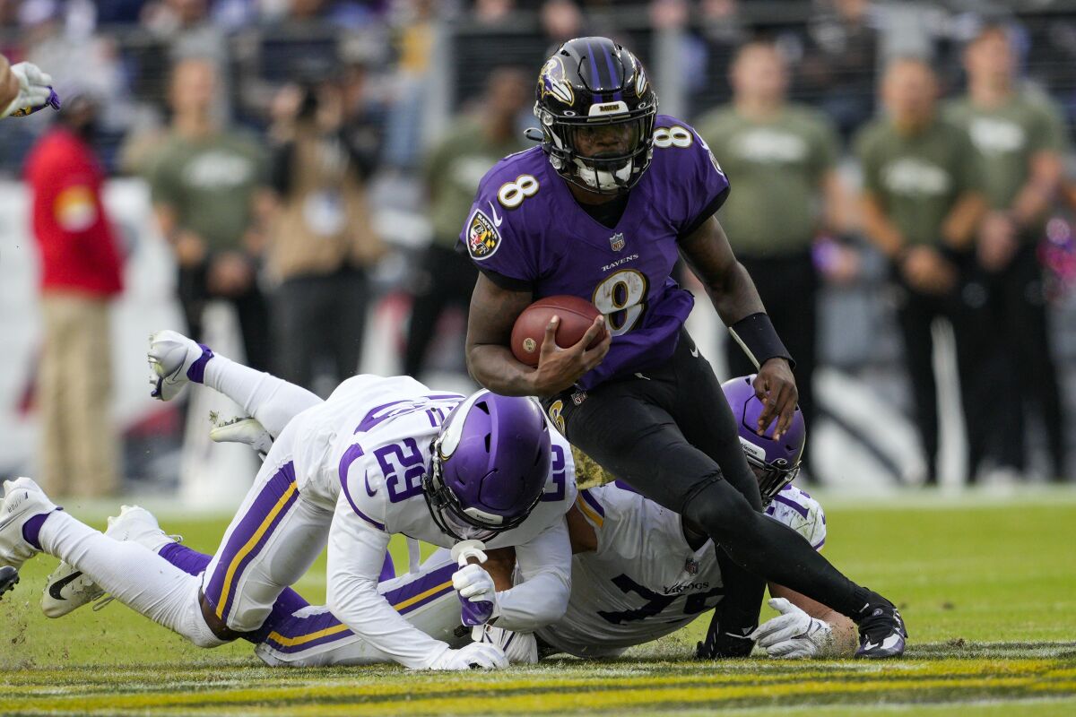 Baltimore Ravens quarterback Lamar Jackson (8) is tackled by Minnesota Vikings defensive back Kris Boyd (29) and defensive end Kenny Willekes (79) during the second half of an NFL football game, Sunday, Nov. 7, 2021, in Baltimore. (AP Photo/Nick Wass)