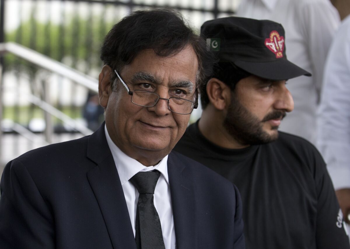 FILE - In this Oct. 8, 2018 file photo, Pakistani lawyer Saiful Malook, left, leaves the Supreme court with a bodyguard, in Islamabad, Pakistan. A Pakistani appeals court on Thursday, June 3, 2021 acquitted a Christian couple sentenced to death on blasphemy charges for allegedly insulting Islam's Prophet Muhammad, their defense lawyer Malook said. (AP Photo/B.K. Bangash, File)