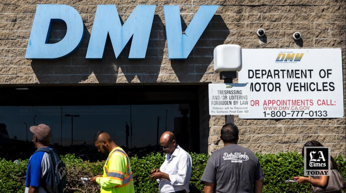 Five people in a row outside a building with the letters "DMV" in that.