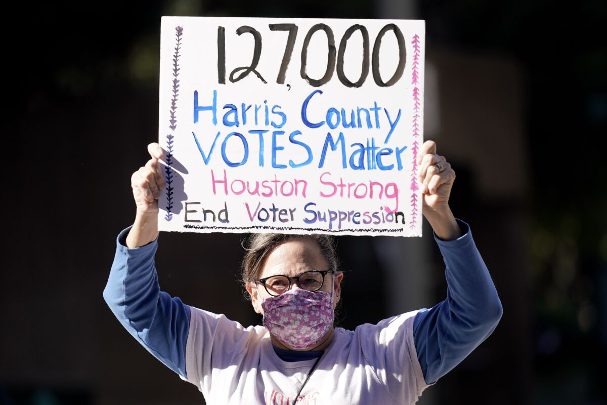 Gina Dusterhoft holds up a sign reading in part, "Harris County Votes Matter." 
