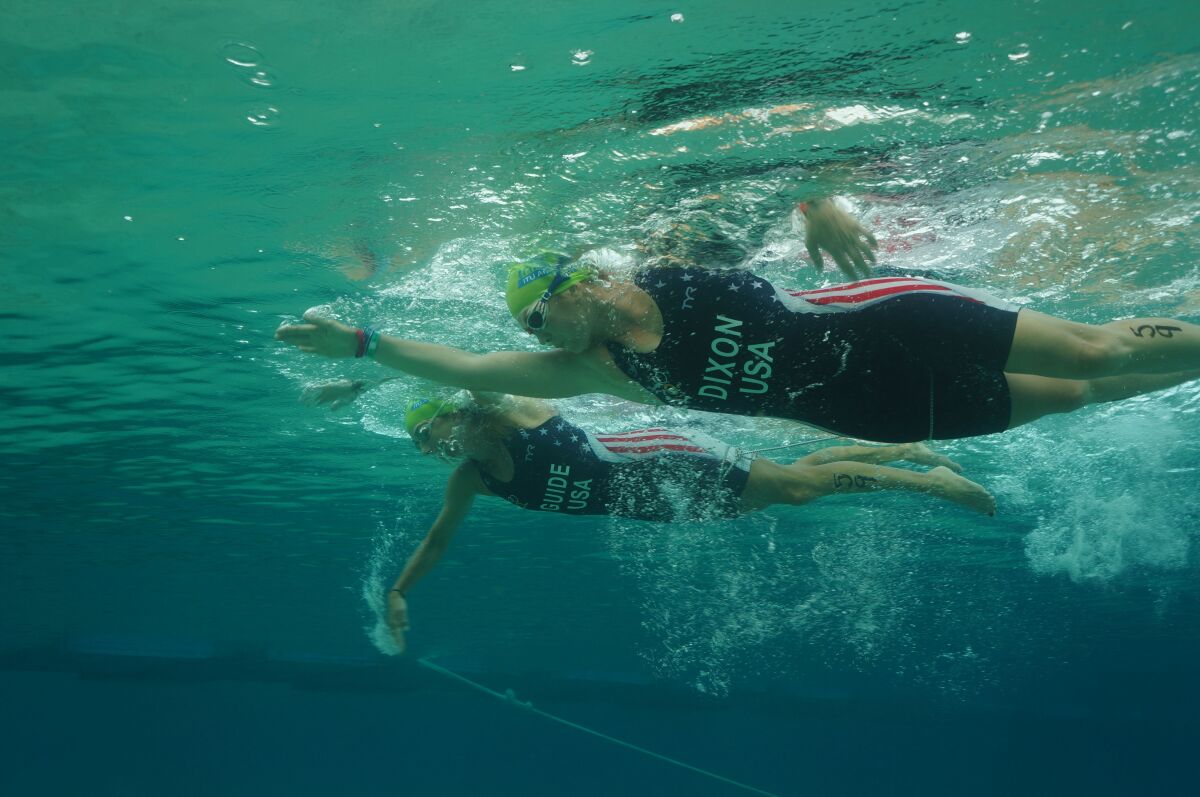 Blind triathlete Amy Dixon, foreground, and her guide Christy Fritts swim in a 2016 aquathon world championship in Mexico.