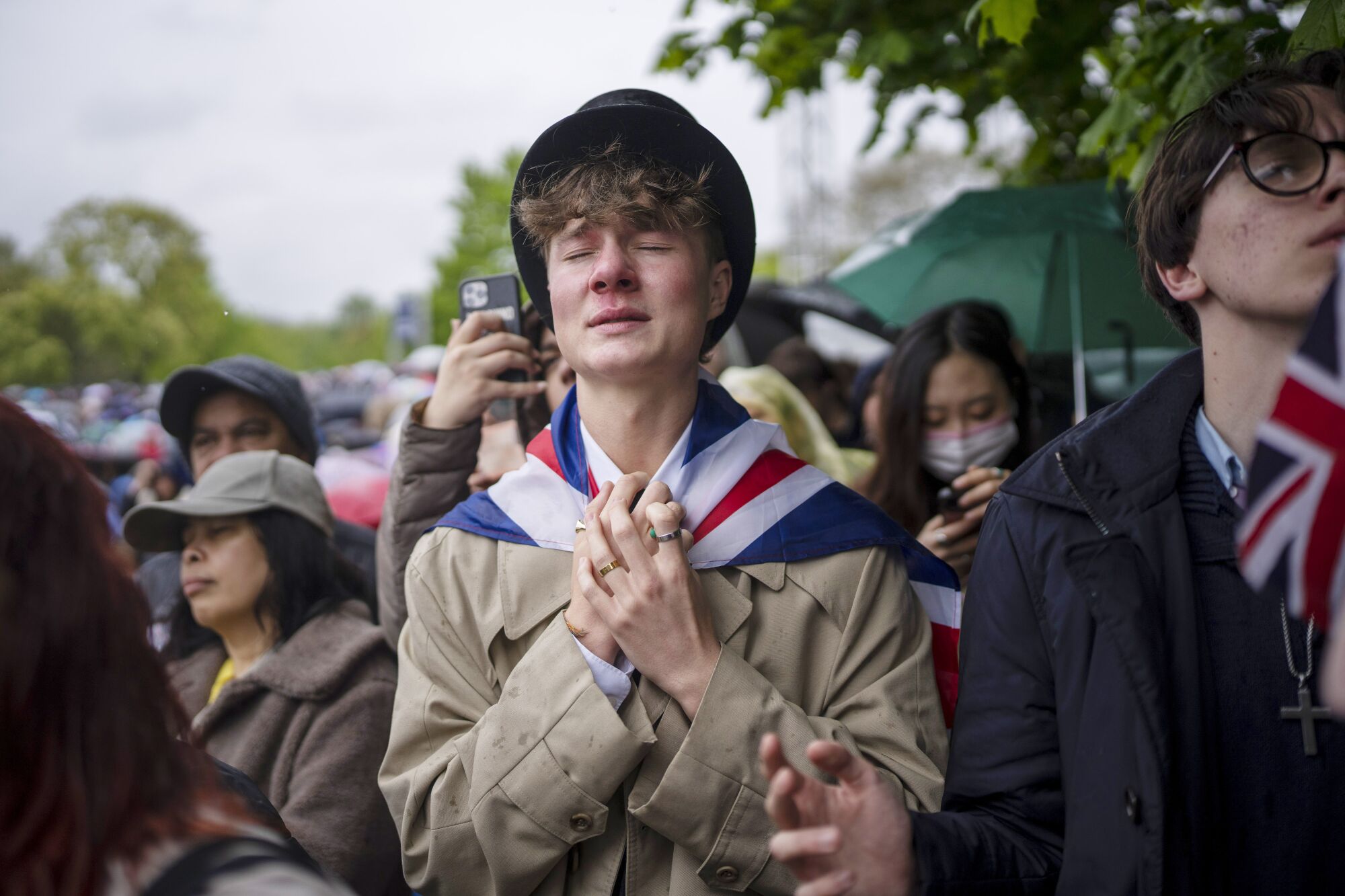 Ben Weller, İngiltere Kralı III. Charles'ın taç giyme törenini Londra'daki Hyde Park'taki bir ekranda izlerken tepki gösteriyor.
