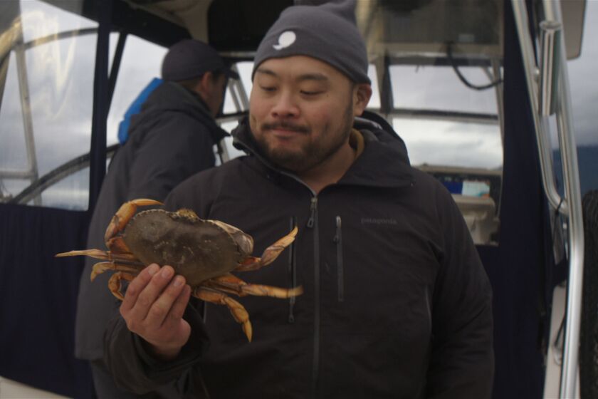 Chef/host David Chang holds a fresh-caught crab in Netflix's "Breakfast, Lunch & Dinner," his follow-up to the acclaimed "Ugly Delicious."