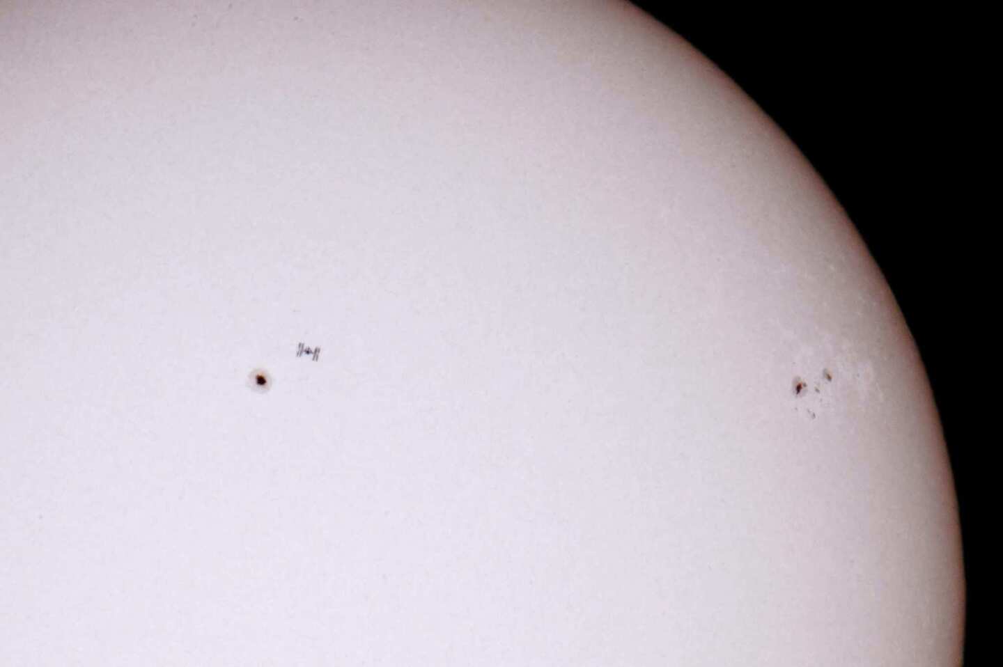 The International Space Station, left, passes in front of the sun as seen in this picture taken from Salgotarjan, northeast of Budapest, Hungary, on Thursday.