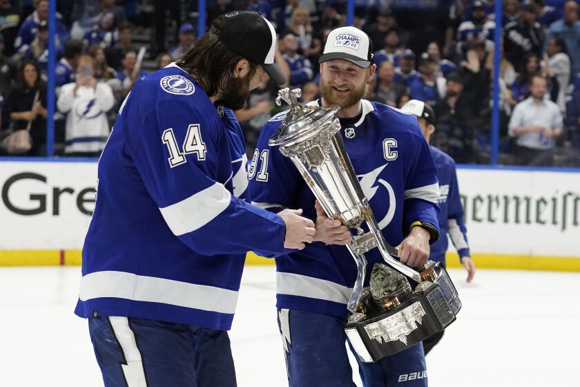 Tampa Bay Lightning center Steven Stamkos (91) shows left wing Pat Maroon (14) the Prince of Wales trophy